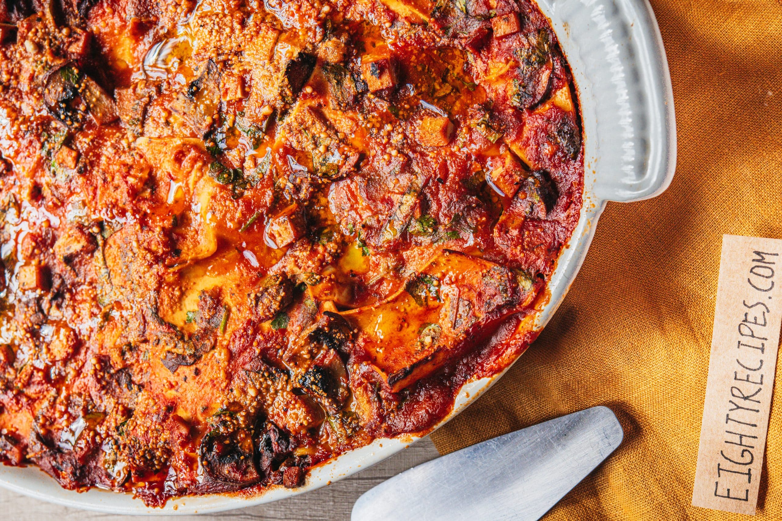 Baked layered pasta with a bubbling tomato and mushroom sauce and a golden nutty top
