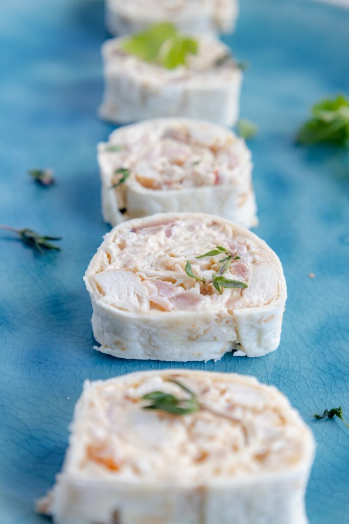 Savory tortilla pinwheels paired with a ranch dipping sauce, showcasing the layers of cheese, chicken, and bacon.