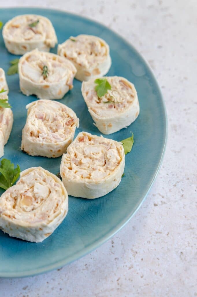 Stack of tortilla pinwheels filled with ranch-seasoned chicken, bacon, and cheddar cheese, arranged neatly for serving.