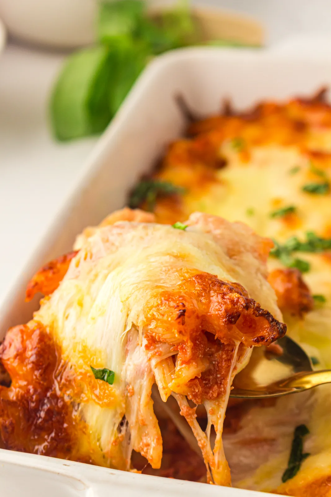 Cheesy spoonful of pasta lifted from the dish with a mozzarella cheese pull