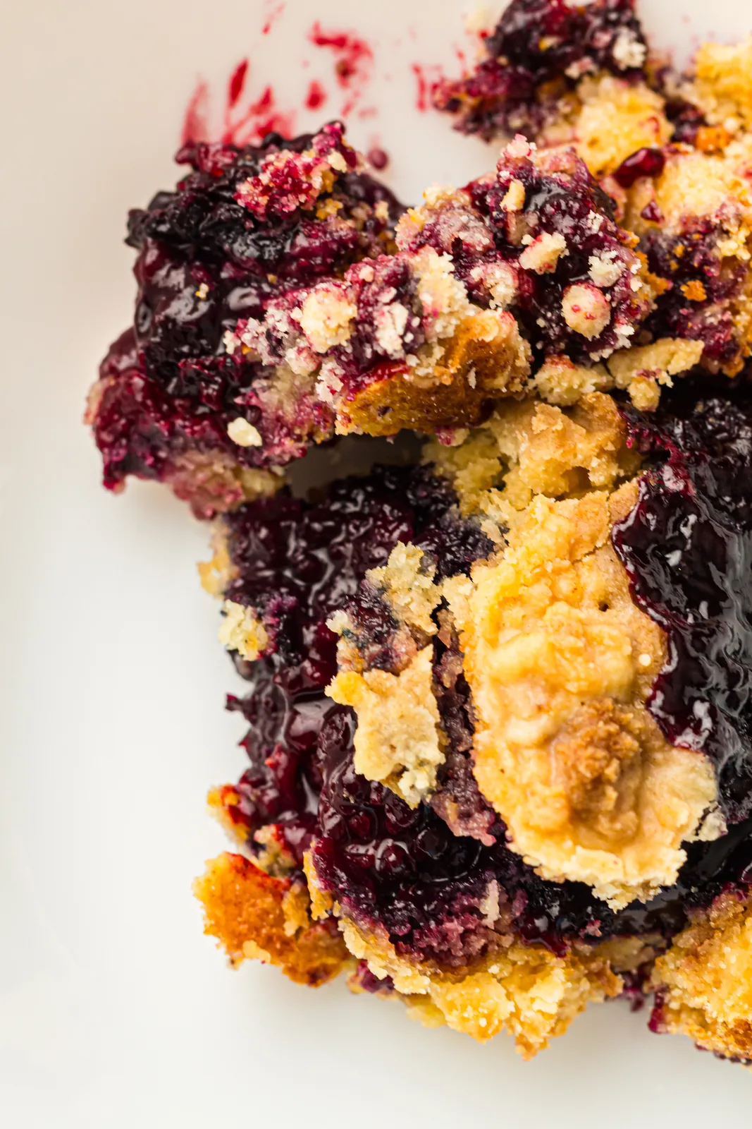 A close up of berry dump cake with bubbling fruit and golden topping