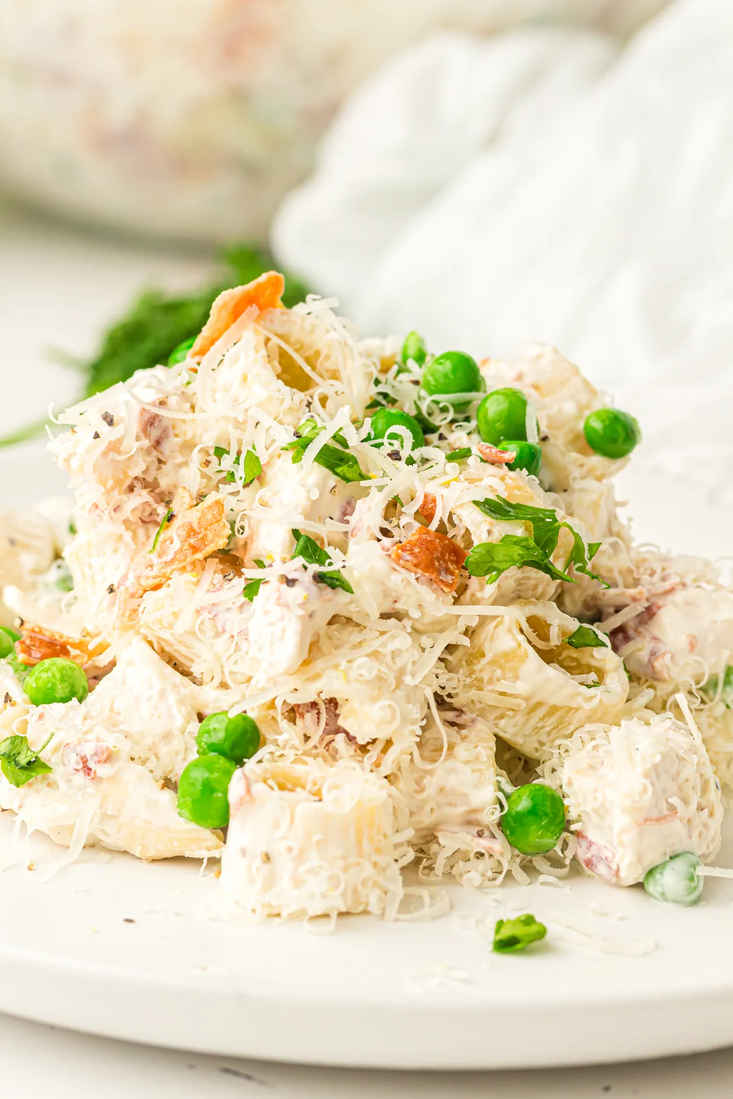 A bowl of creamy chicken pasta salad with peas and bacon