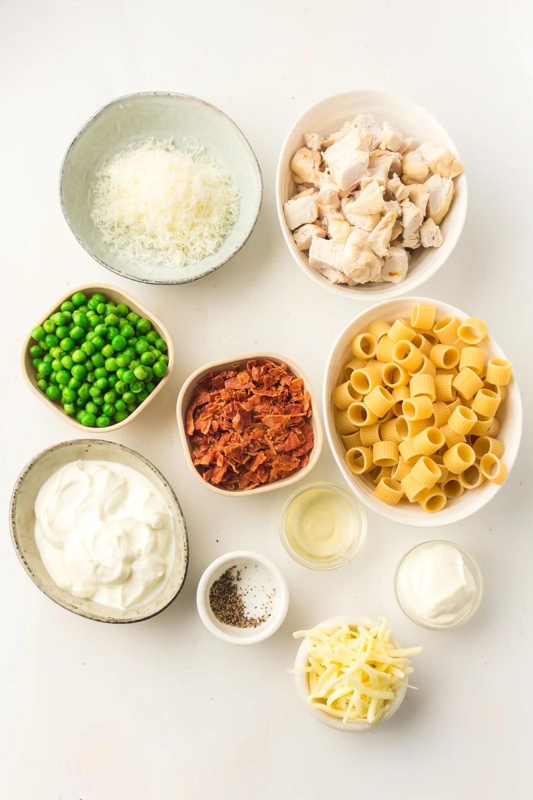 Ingredients for chicken pasta salad including rotini, bacon and peas