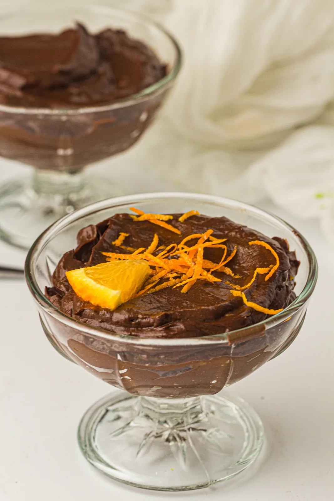 Two glasses of a silky dairy free dessert topped with orange zest