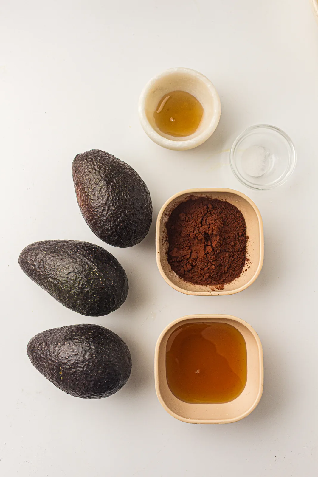 Ingredients for chocolate avocado mousse: ripe avocados, cocoa powder, maple syrup, vanilla, and salt