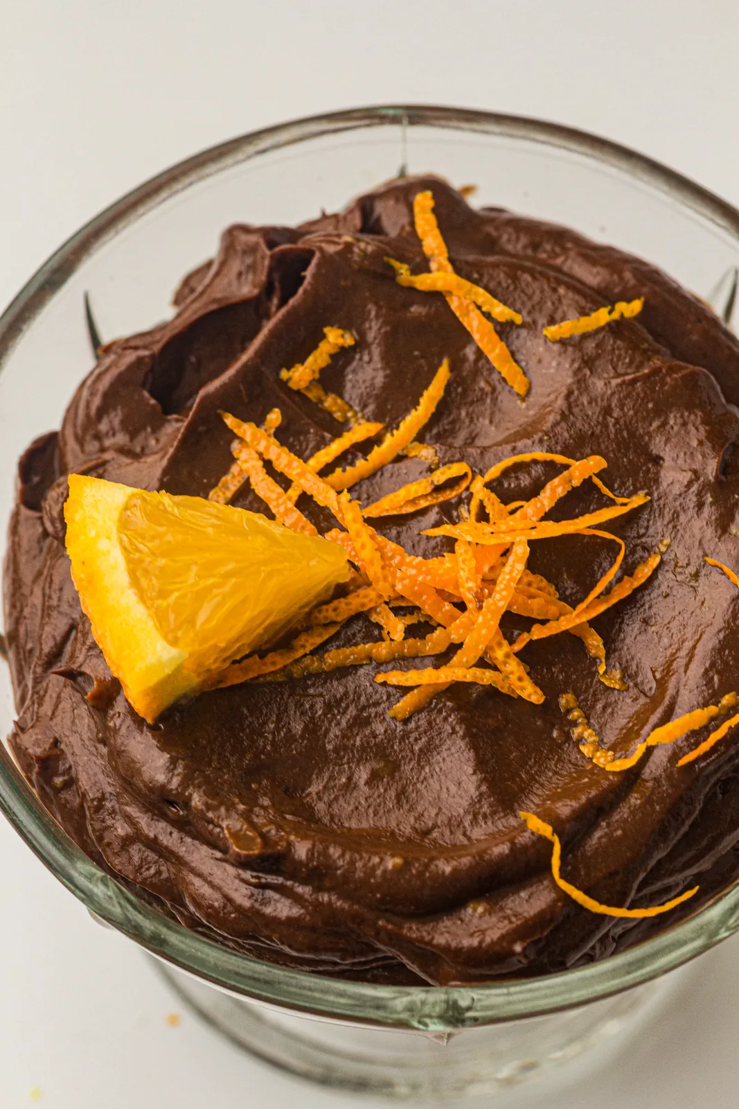 Chocolate avocado mousse garnished with an orange wedge and zest