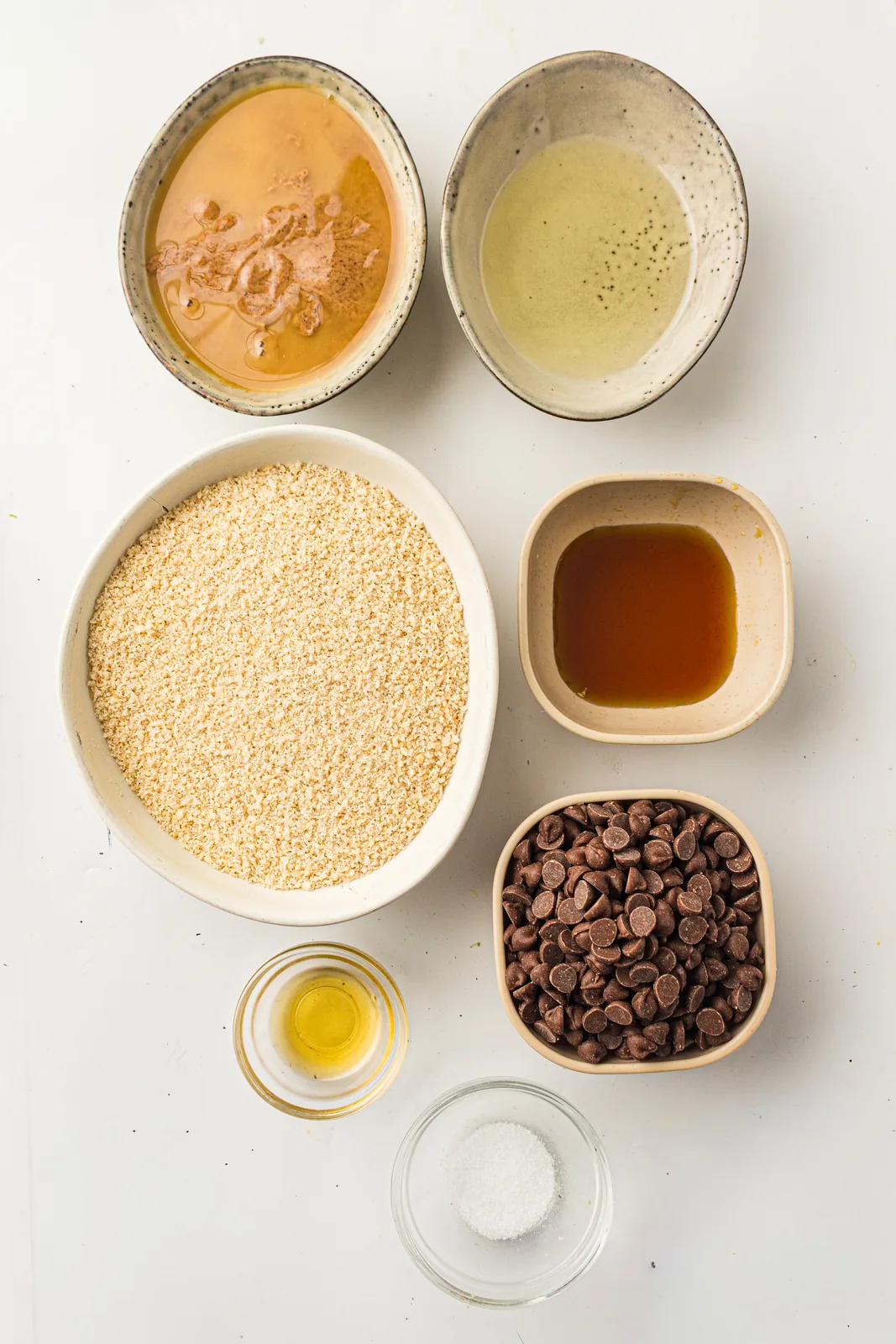 Ingredients for chocolate caramel bars: almond flour, almond butter, maple syrup, and dark chocolate
