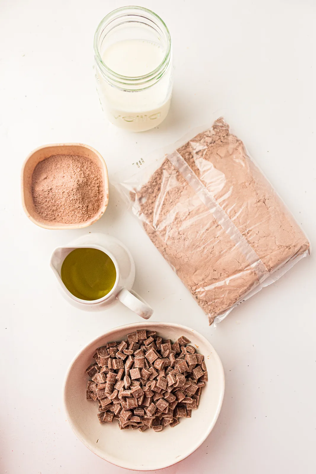 Ingredients for chocolate dump cake: chocolate cake mix, pudding mix, milk, oil, and chocolate chips