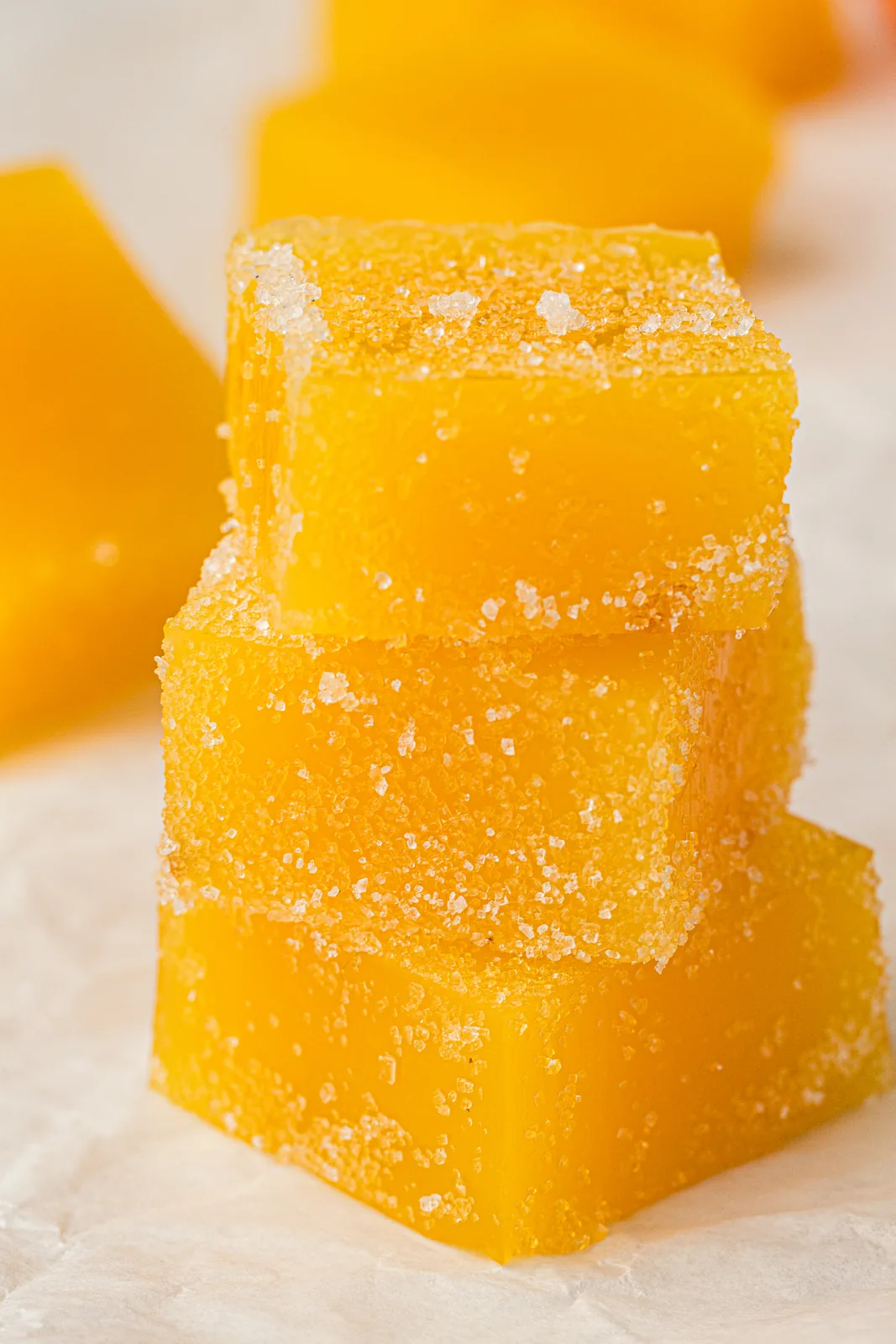 Glossy citrus cubes beside a sliced orange