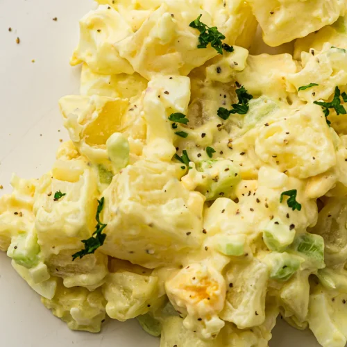 A plate of creamy classic potato salad with celery and egg