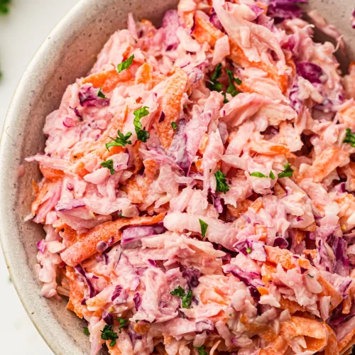 A bowl of creamy coleslaw with red cabbage and carrots