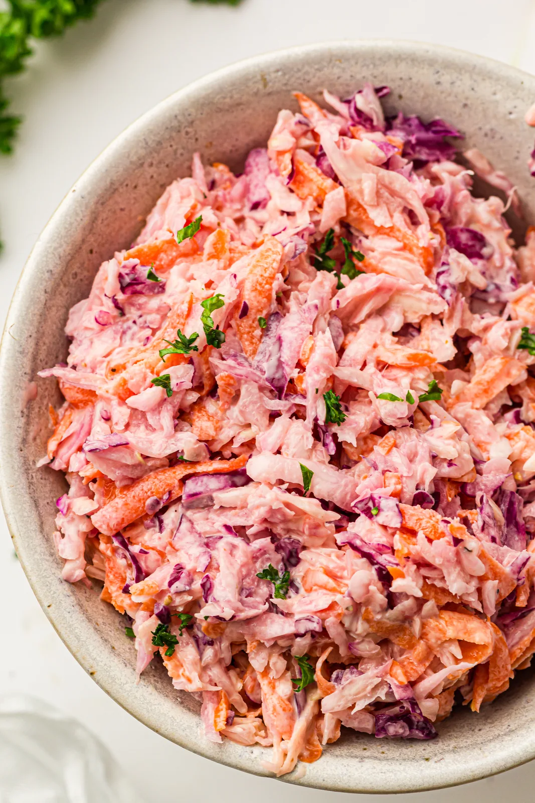 A bowl of creamy coleslaw with shredded red cabbage and carrots