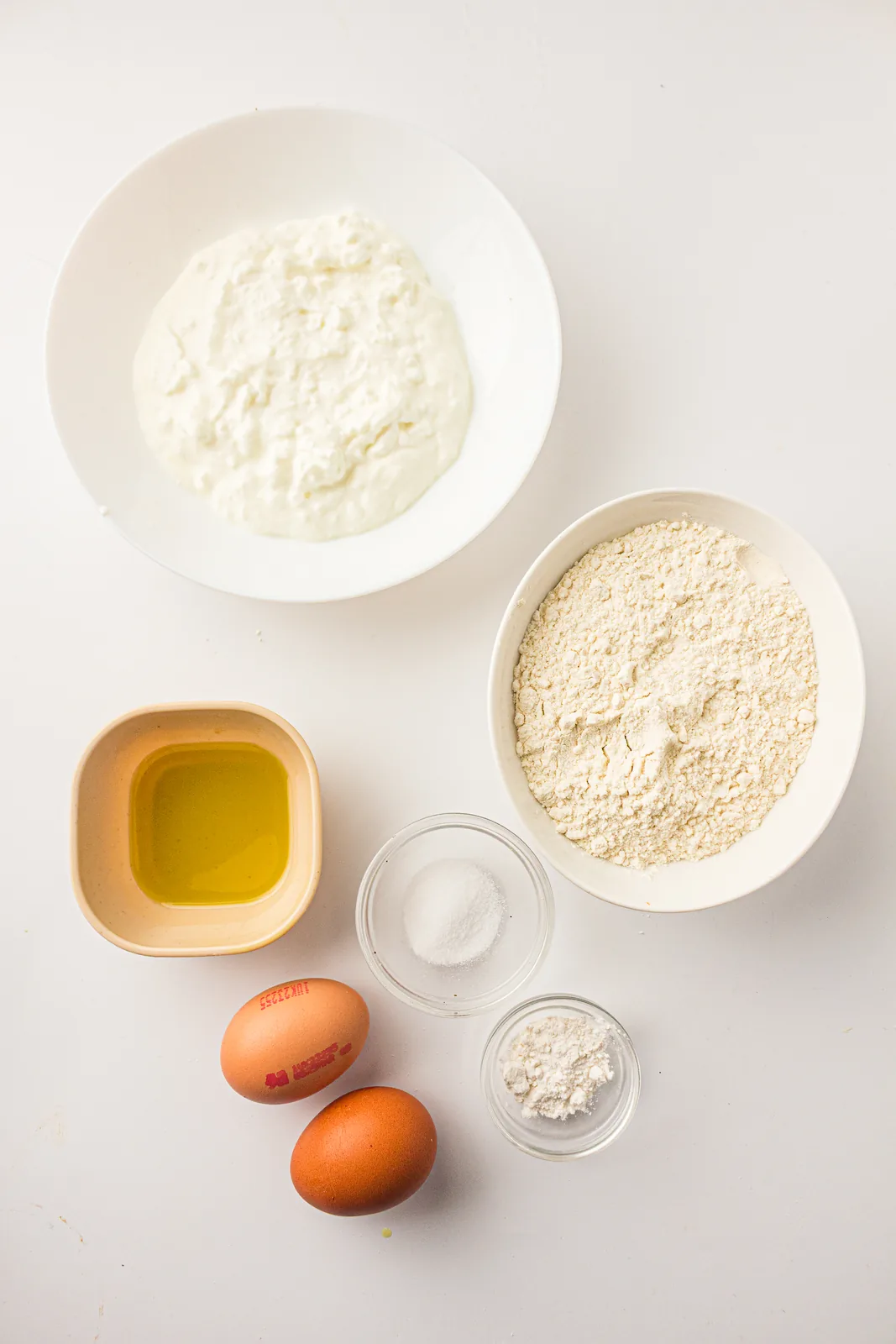 Ingredients for cottage cheese bread: cottage cheese, eggs, flour, baking powder, salt, and olive oil