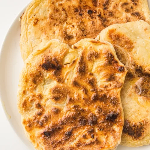 Golden cottage cheese flatbread rounds on a white plate