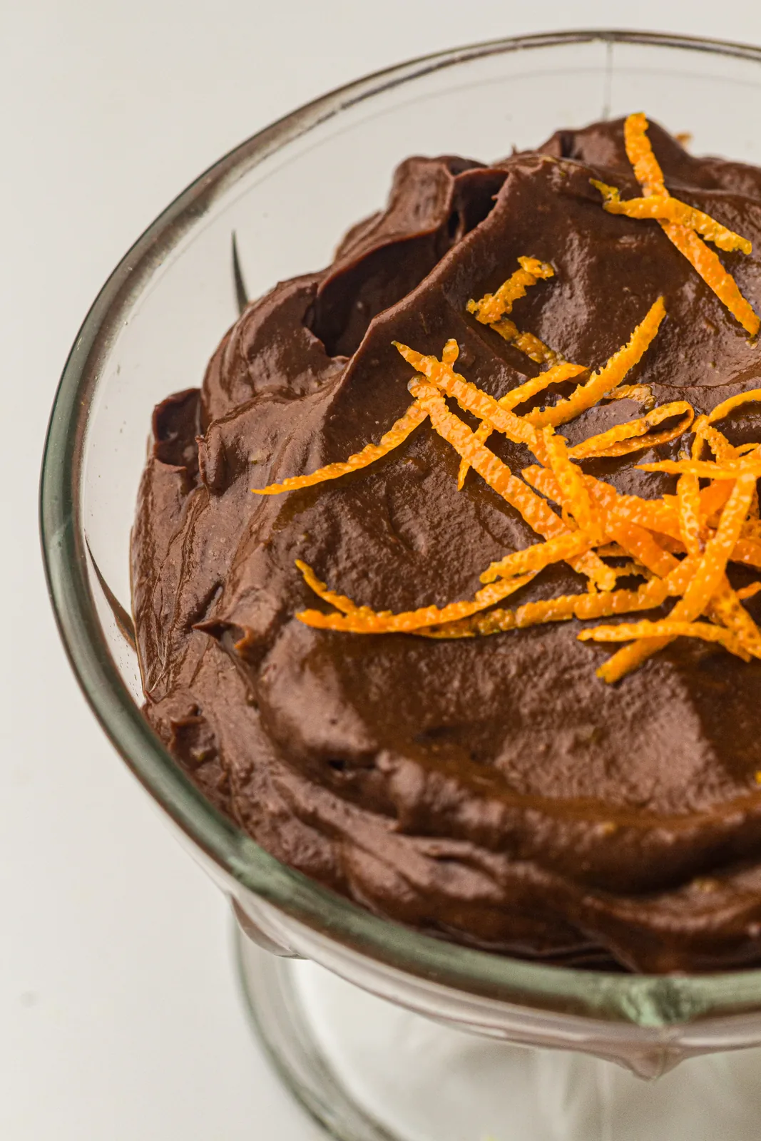 A creamy dark dessert topped with fresh orange zest