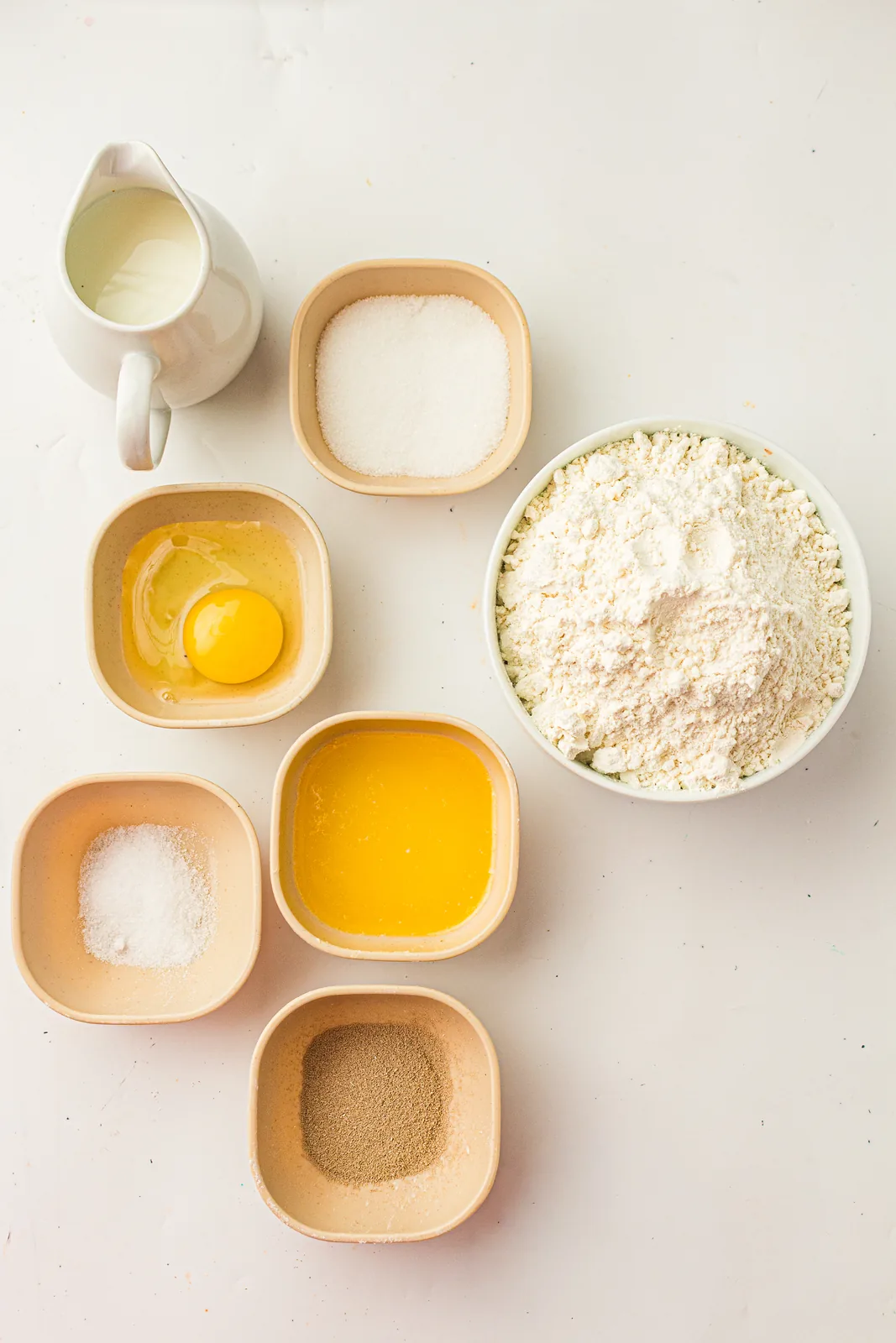 Ingredients for dinner rolls: flour, milk, egg, butter, sugar, and yeast