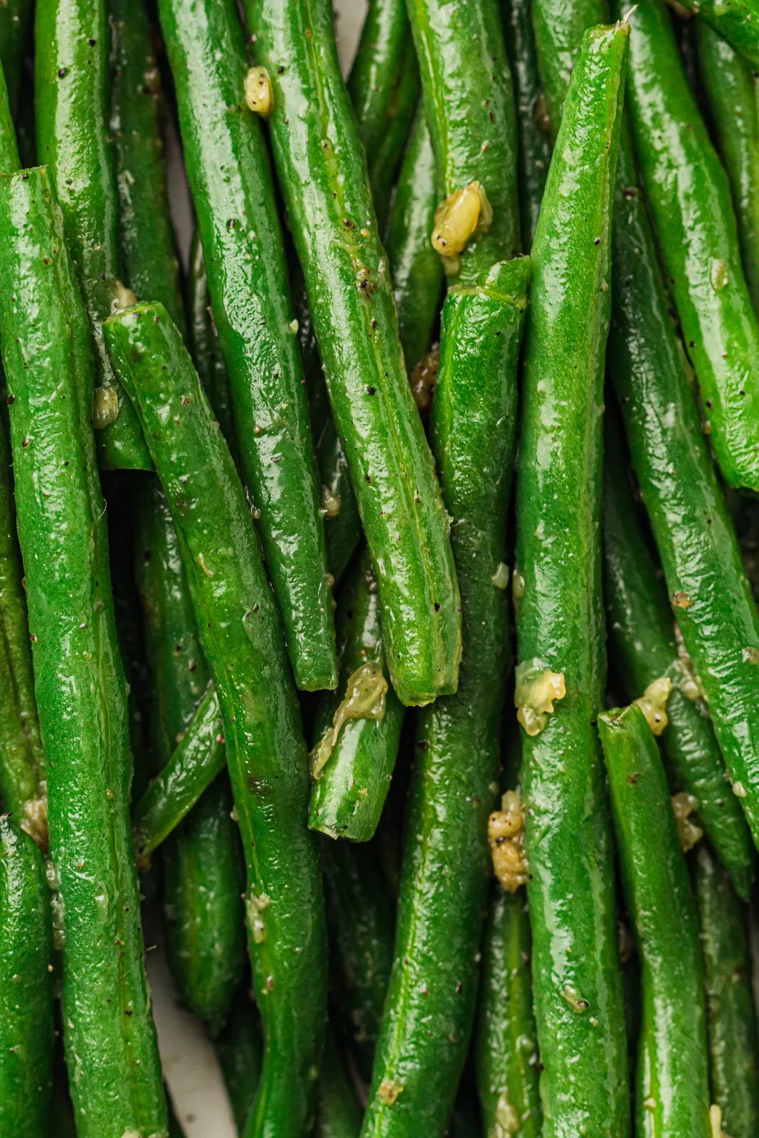 Garlic butter green beans, glossy and speckled with black pepper