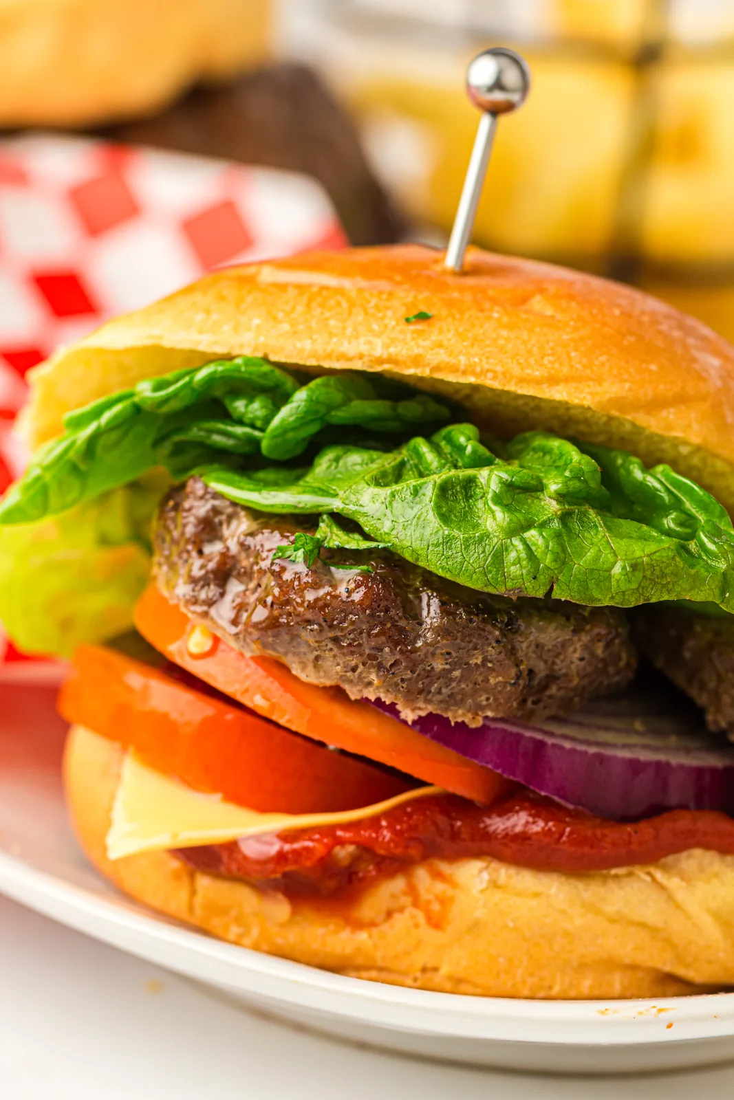 Thick charred patty with lettuce, tomato, red onion and cheese in a soft bun
