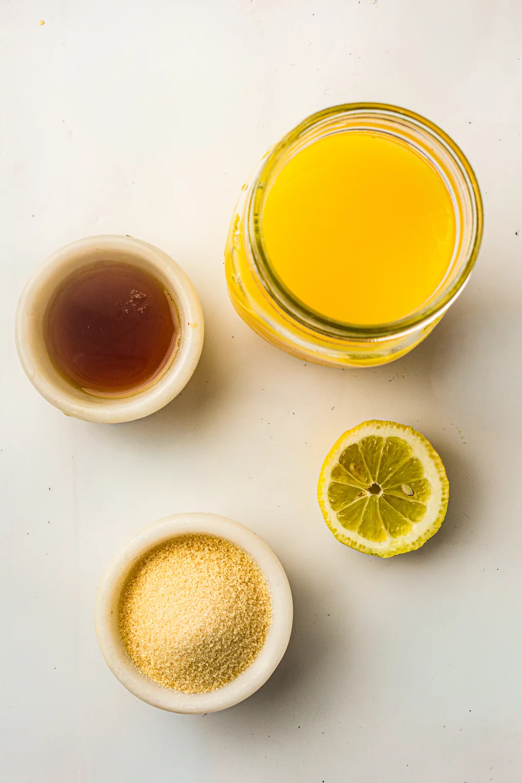 Ingredients for homemade gummies: orange juice, gelatin, honey, and lemon
