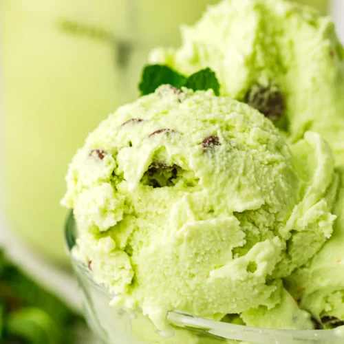 Mint chocolate chip ice cream scoops in a glass dish