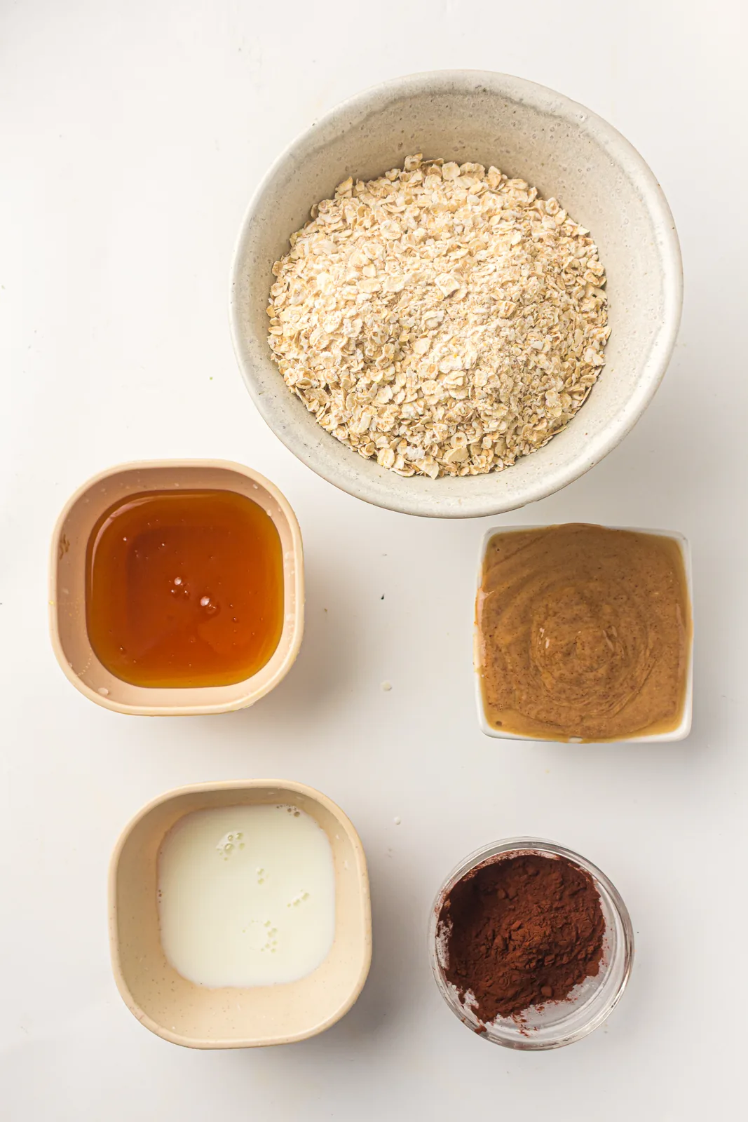 Ingredients for peanut butter oat balls in small bowls