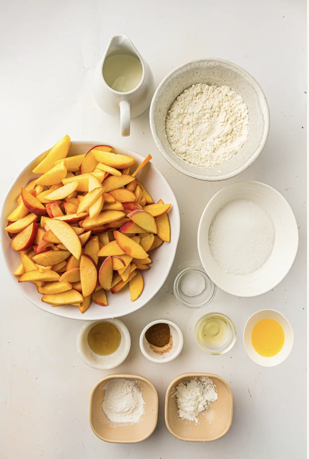 Ingredients for peach cobbler: fresh peaches, sugar, flour, butter, and milk