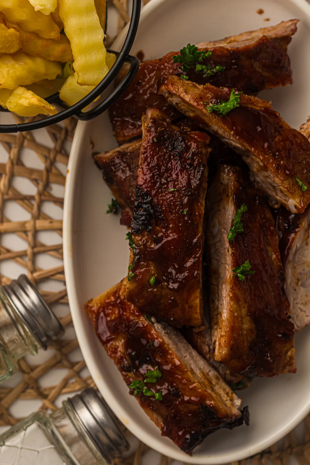 A charred, sticky rack of barbecue ribs resting before slicing