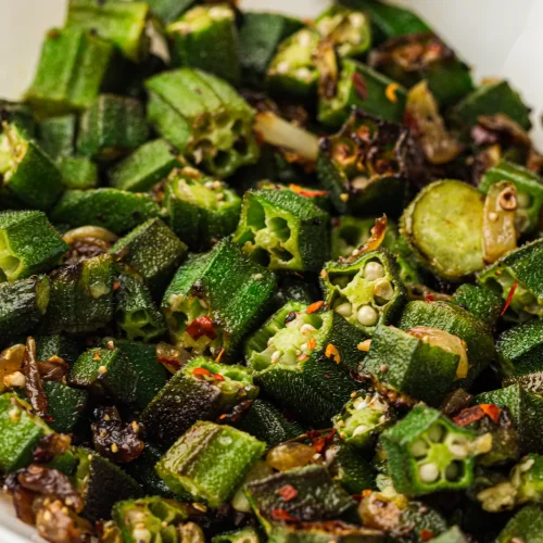 Sauteed okra with red pepper flakes in a white bowl