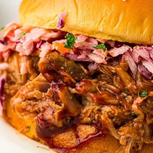 Slow cooker pulled pork sandwich with coleslaw on a brioche bun