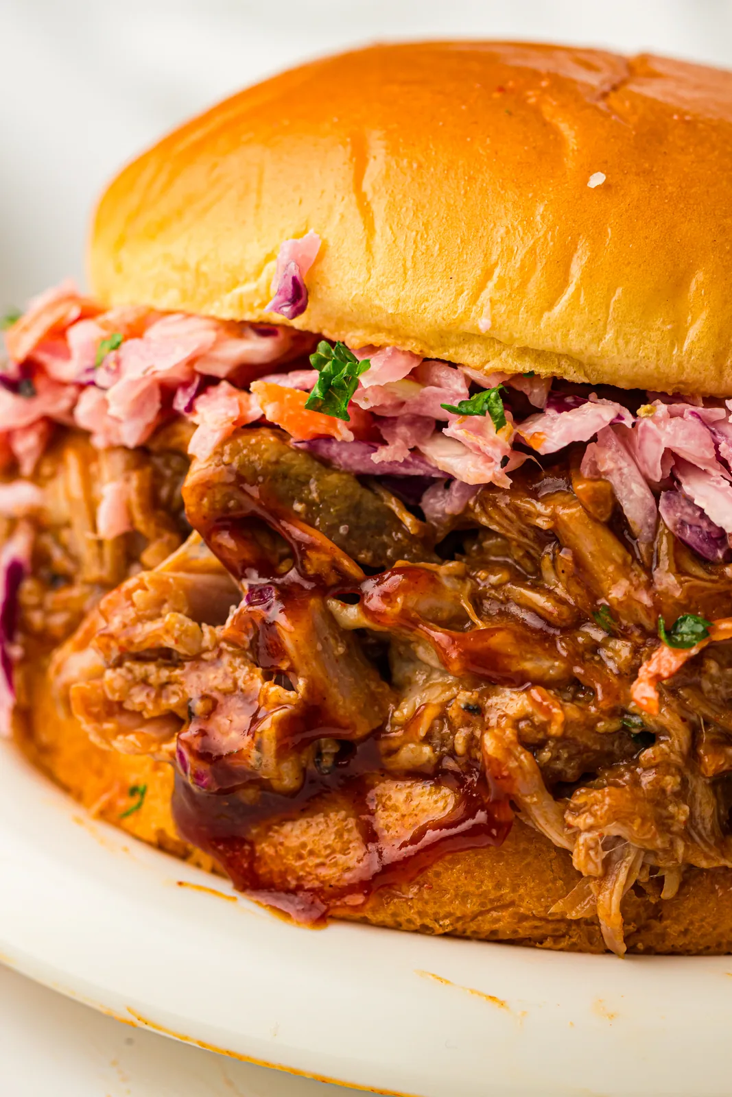 Slow cooker pulled pork sandwich with coleslaw on a brioche bun