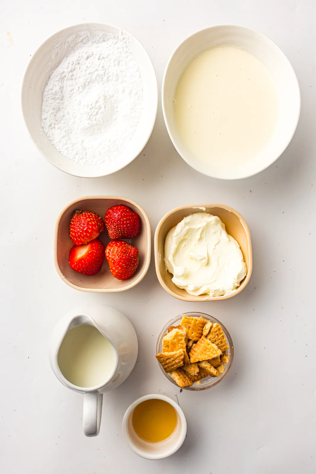 Ingredients for strawberry cheesecake ice cream: milk, cream, cream cheese, strawberries, and biscuit