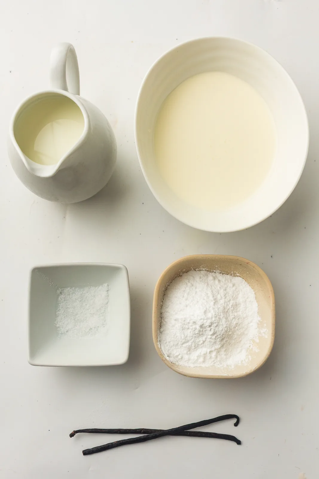 Ingredients for vanilla ice cream: milk, cream, sugar, and vanilla pods