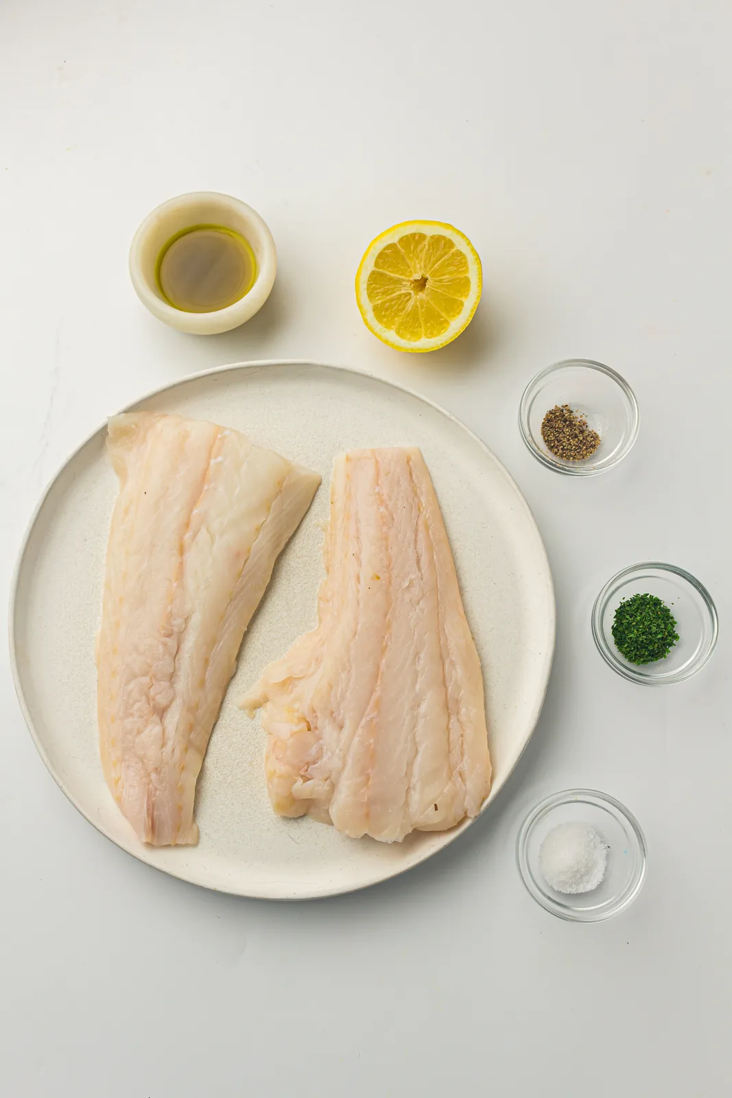 Ingredients for air fryer cod: cod fillets, lemon, oil, parsley and seasoning