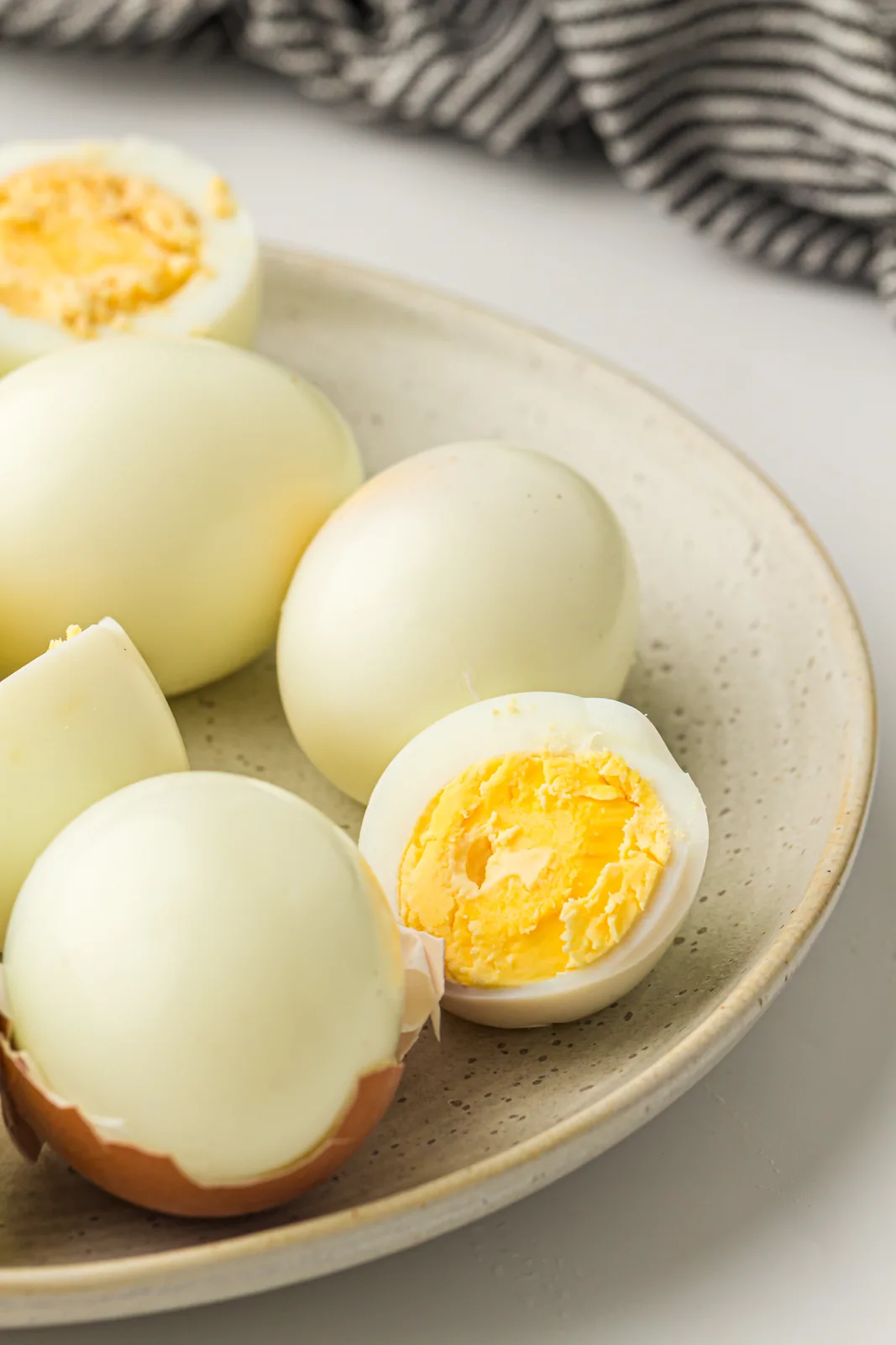 Air fryer hard boiled eggs peeled on a plate with one cut in half