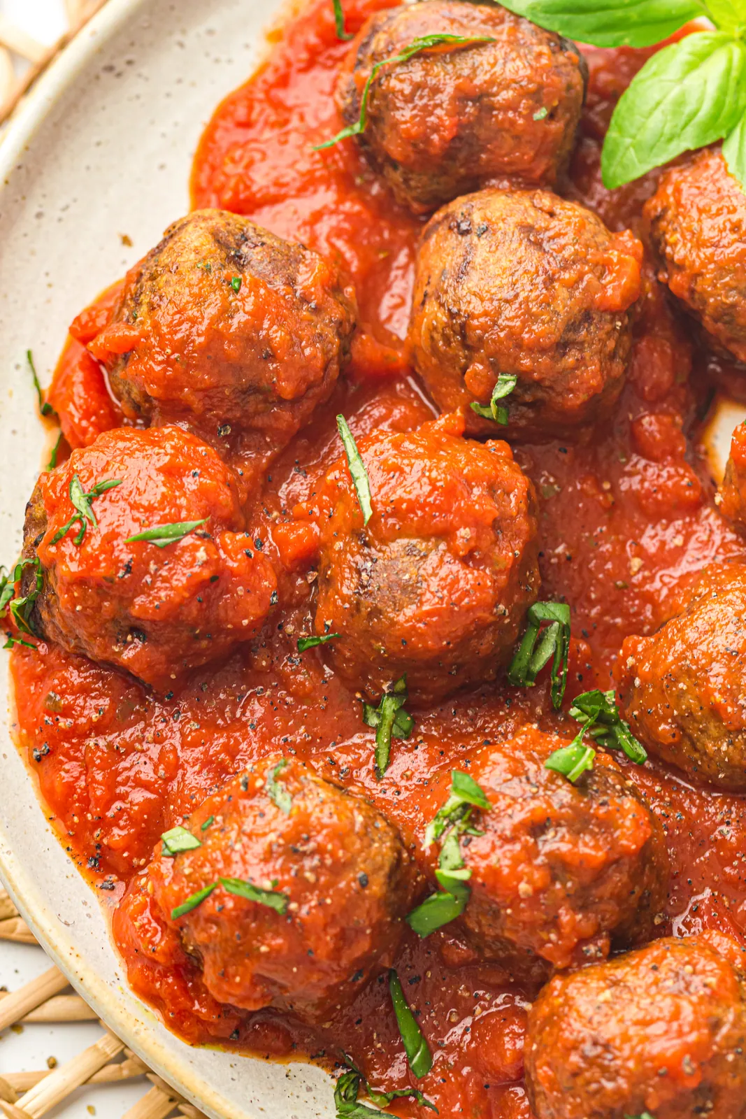 Browned meatballs tossed through tomato sauce with basil