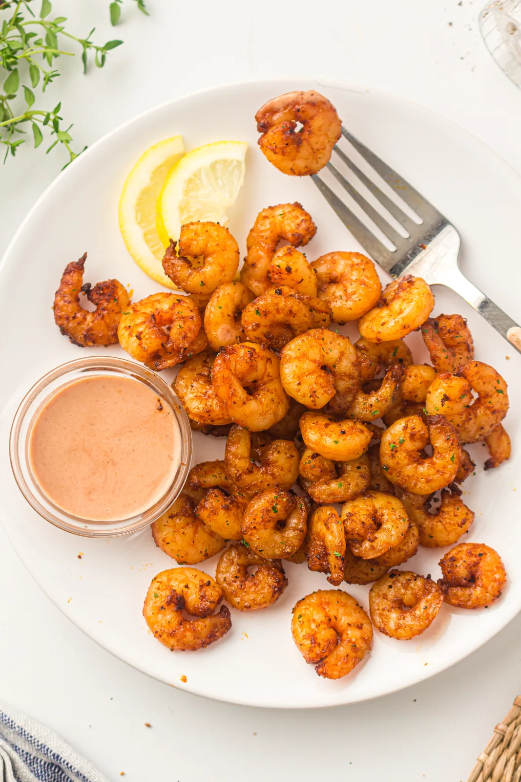 Fork lifting a single plump seasoned prawn