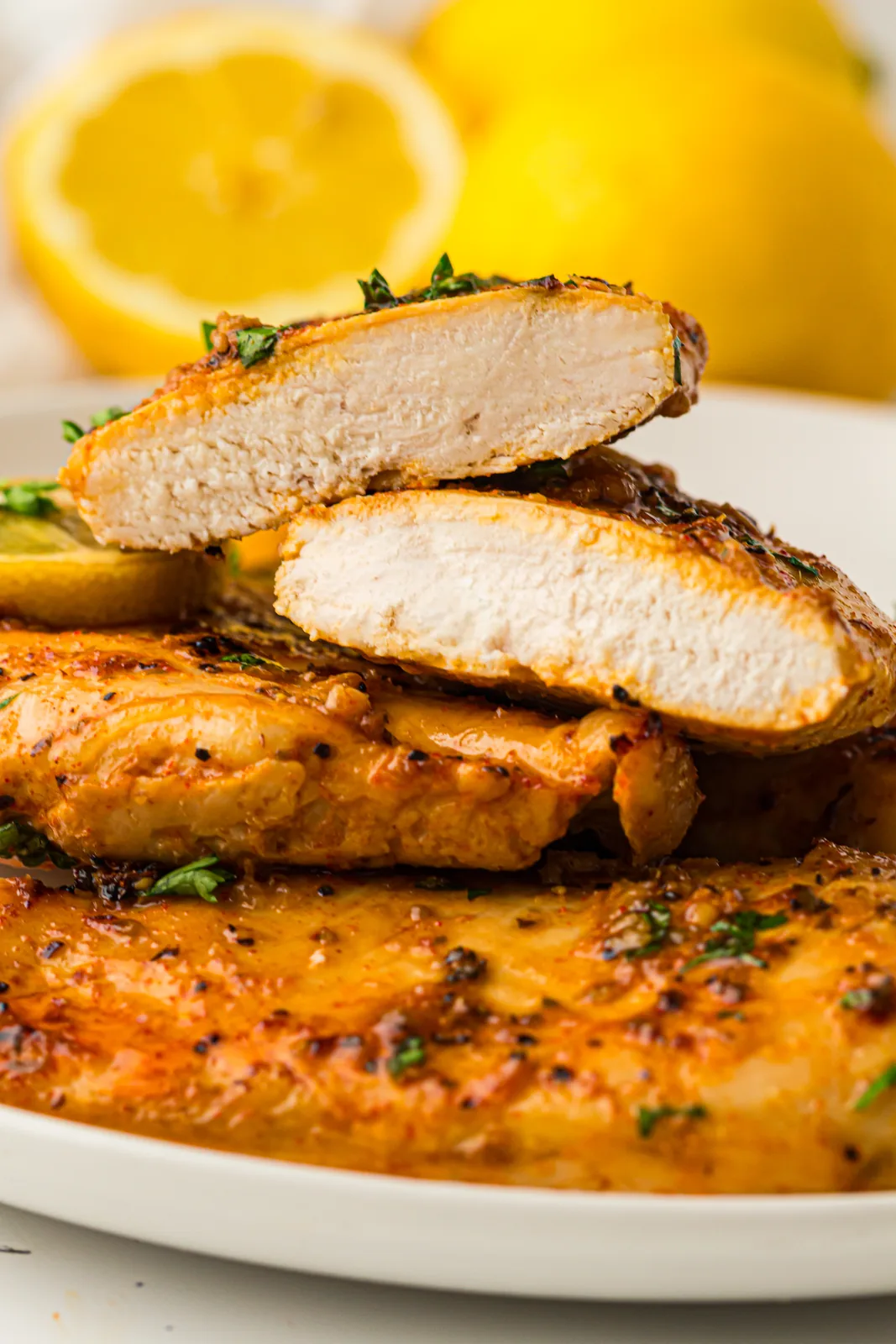 Sliced chicken breast stacked on a plate showing a juicy white centre