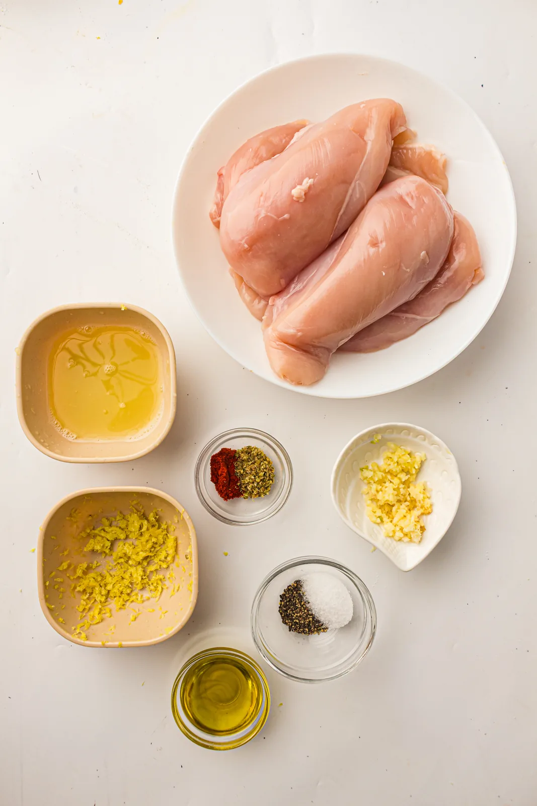 Ingredients for baked lemon chicken: chicken breasts, olive oil, garlic, lemon, oregano, paprika, salt and pepper