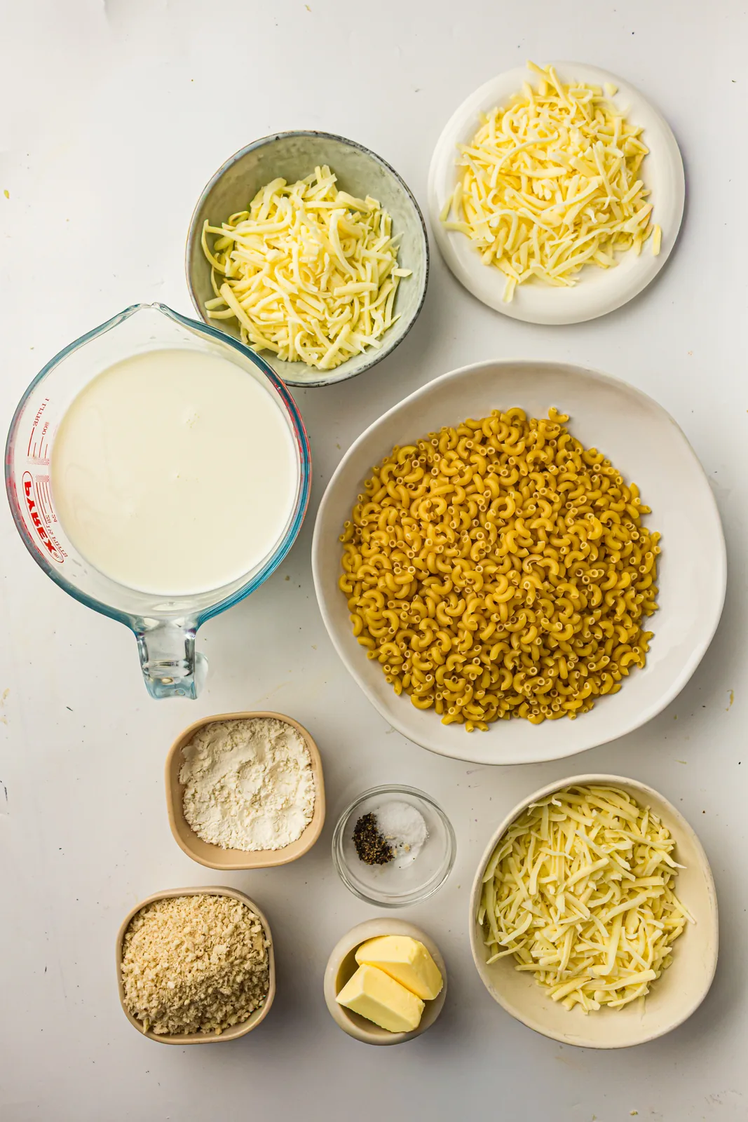 Ingredients for baked mac and cheese: elbow macaroni, butter, flour, milk, cheddar, mozzarella, Monterey Jack and breadcrumbs
