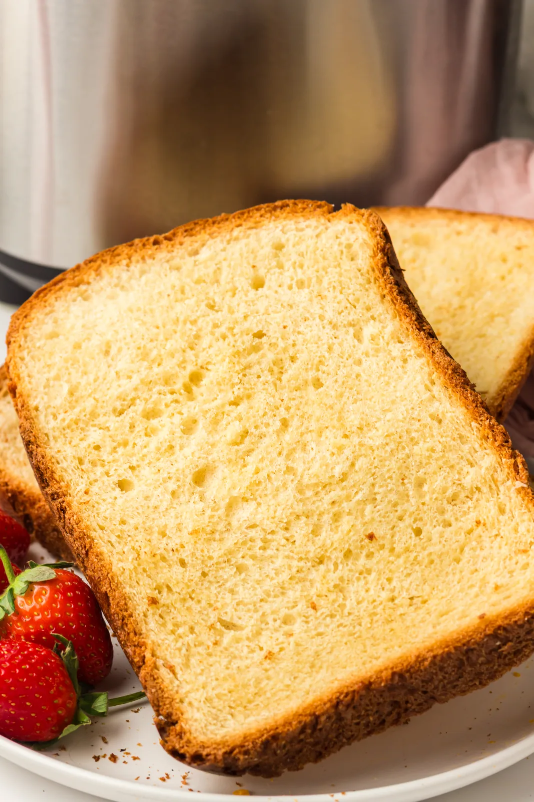 Thick slices of bread machine brioche on a plate with strawberries
