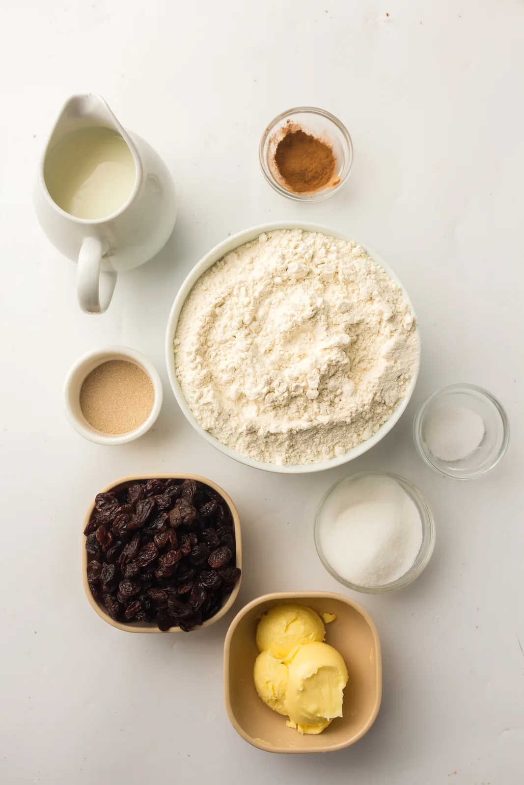 Ingredients for bread machine cinnamon raisin bread: flour, milk, raisins, butter, sugar, ground cinnamon, salt and yeast