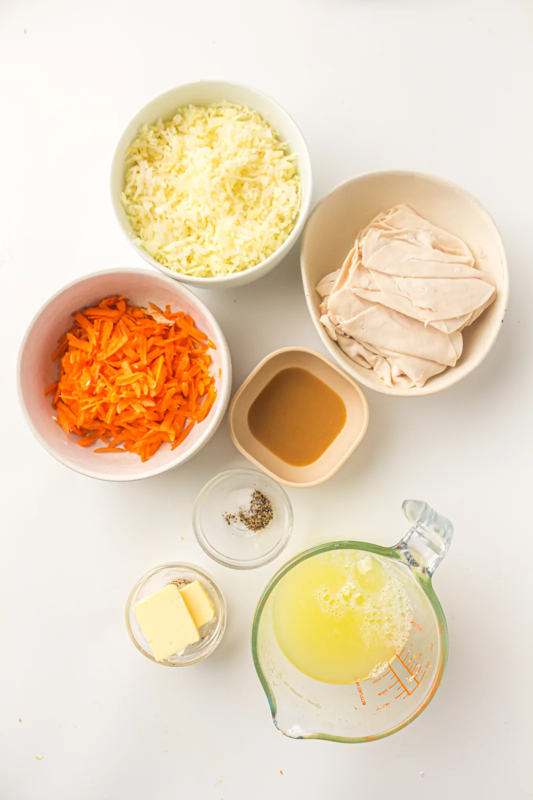 Ingredients for egg white wraps: liquid egg whites, deli turkey, shredded cabbage, grated carrot, butter, salt and pepper