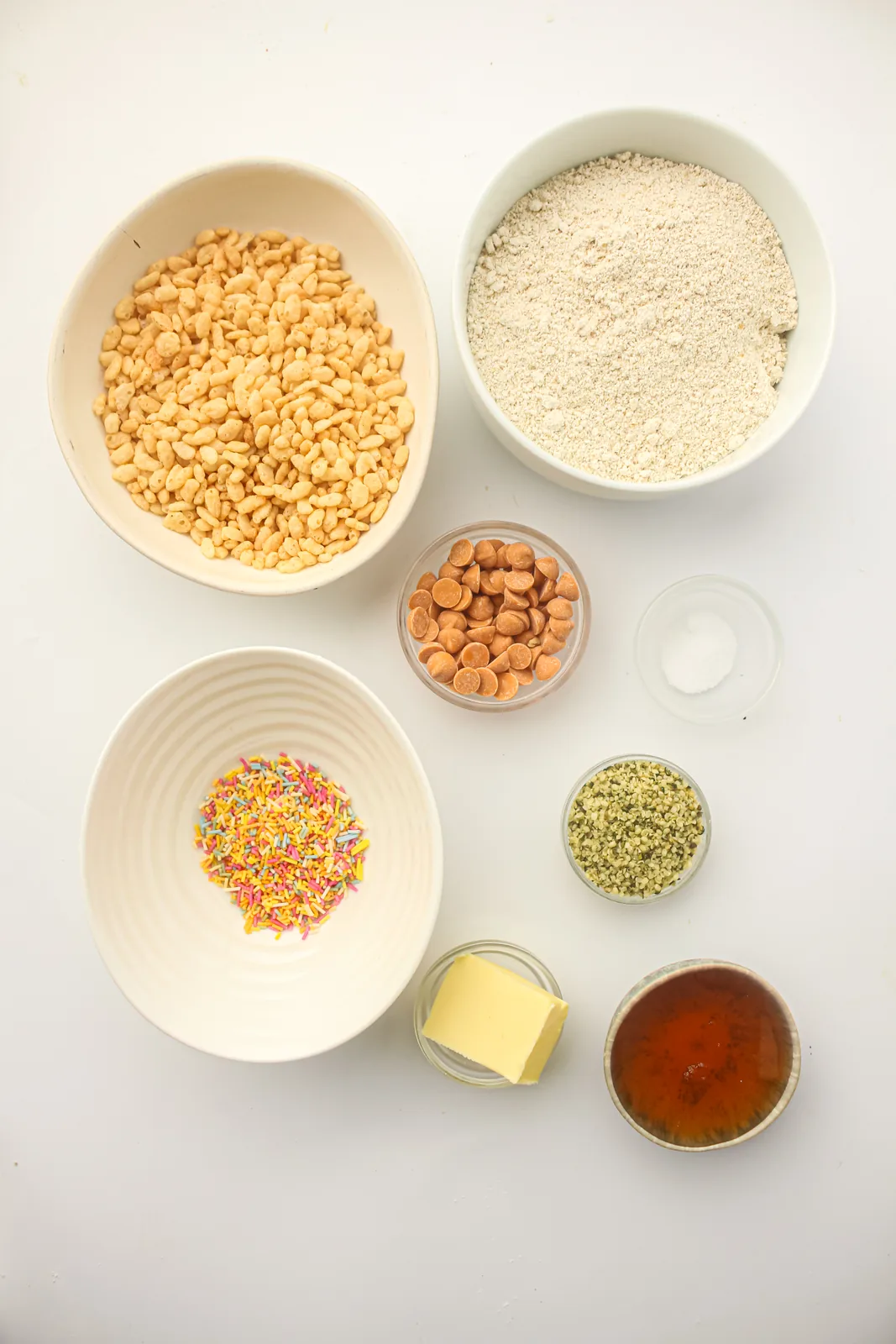 Ingredients for energy balls: oat flour, hemp seeds, honey, butter, butterscotch chips, sprinkles and rice crisps