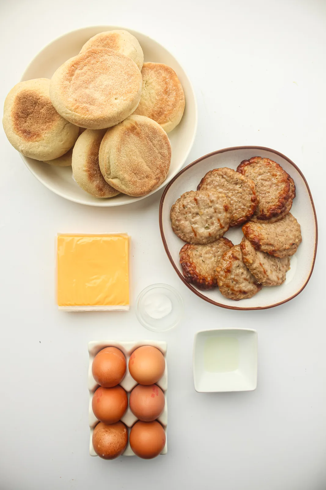 Ingredients for freezer breakfast sandwiches: English muffins, eggs, cheese slices, sausage patties and butter