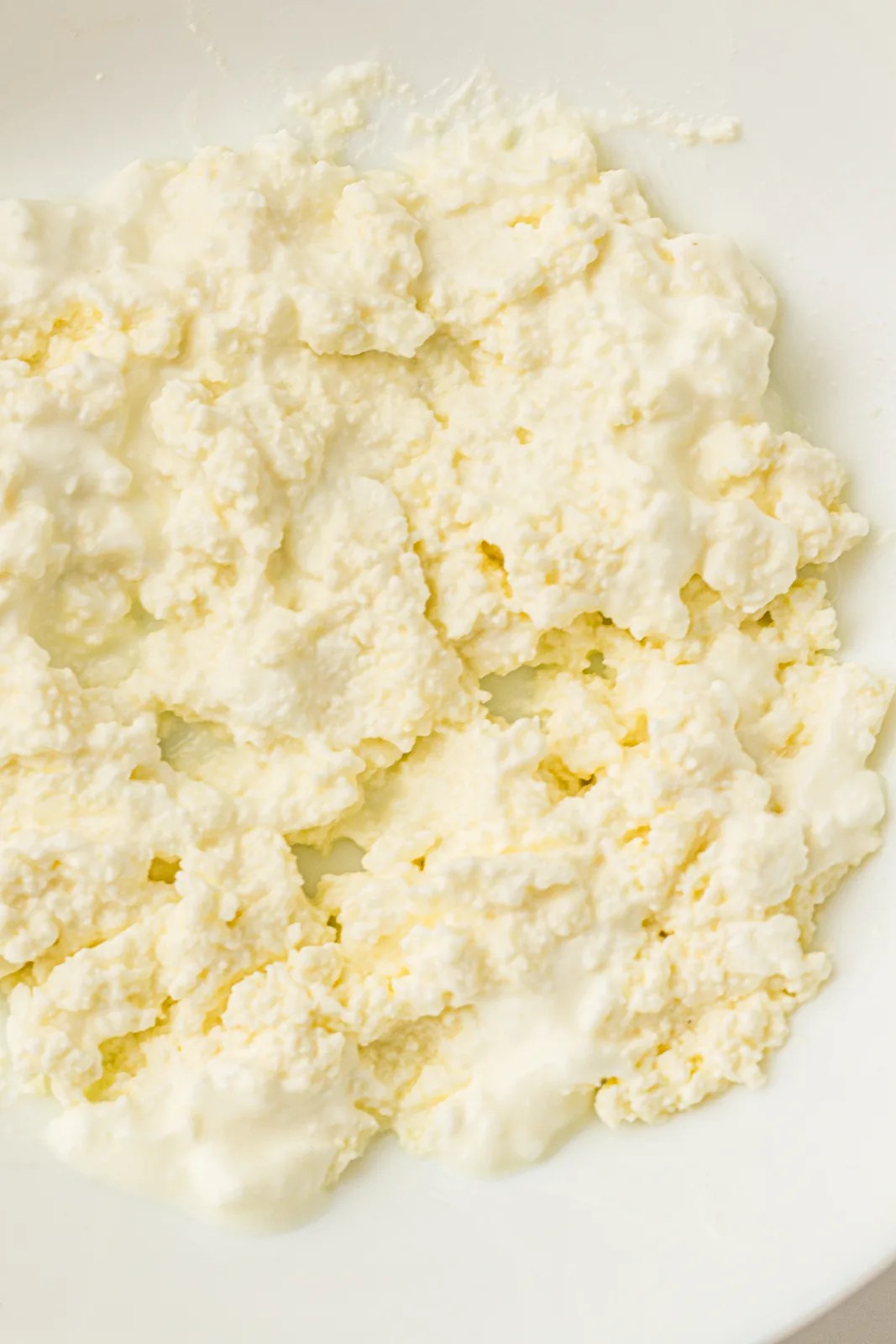 Close view of loose white curds spread across a shallow dish