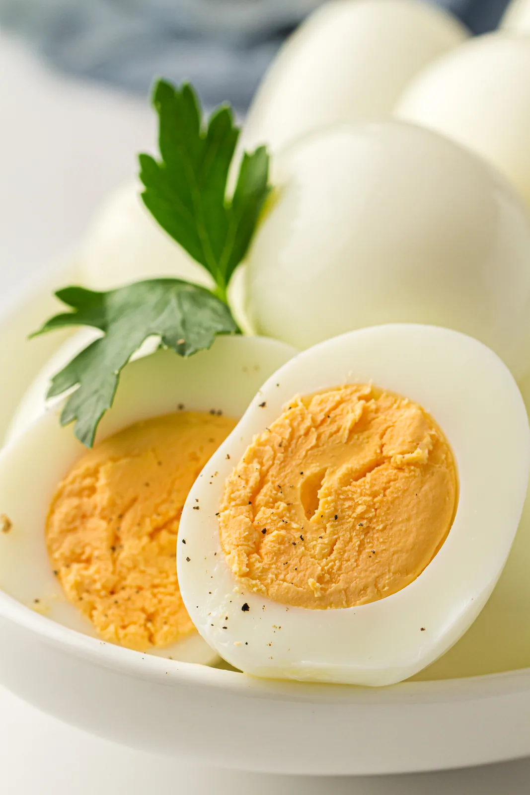 Halved whites showing firm golden yolks, garnished with parsley on a plate