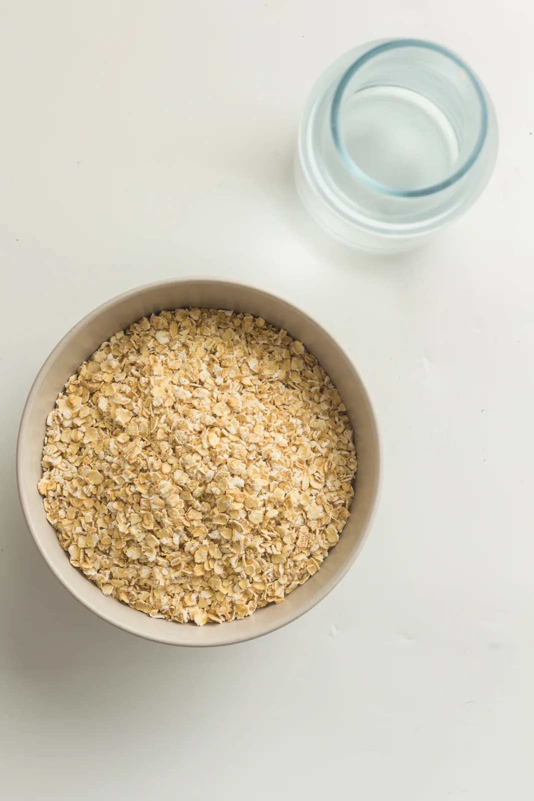 Ingredients for instant pot oatmeal: a bowl of rolled oats and a jug of water