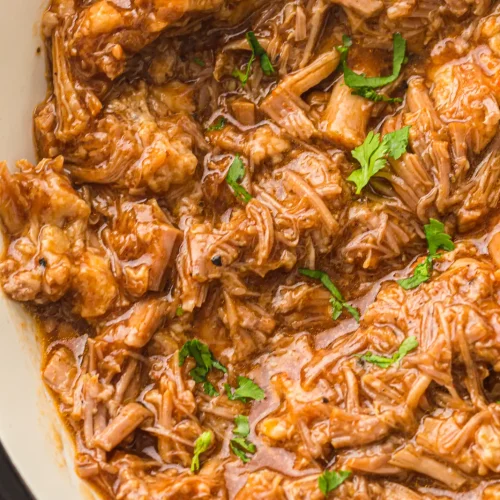 Instant pot pulled pork shredded and coated in barbecue sauce in the inner pot