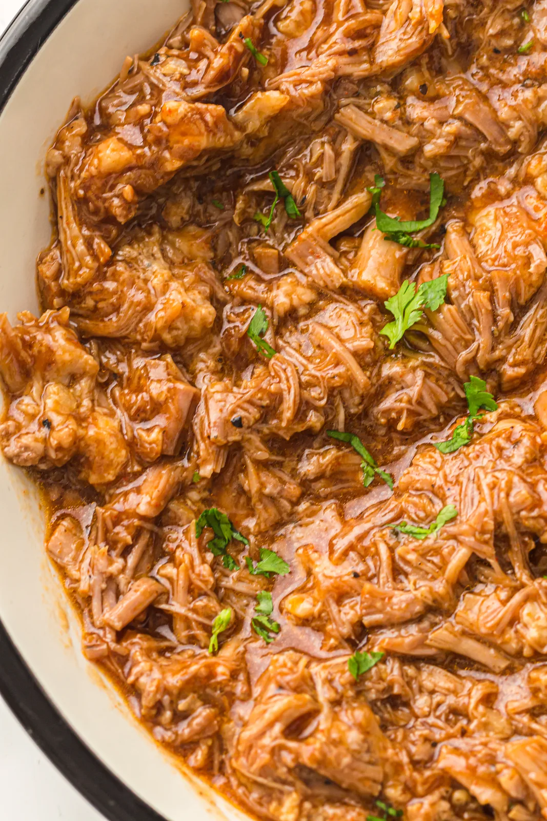 Instant pot pulled pork shredded and coated in barbecue sauce in the inner pot