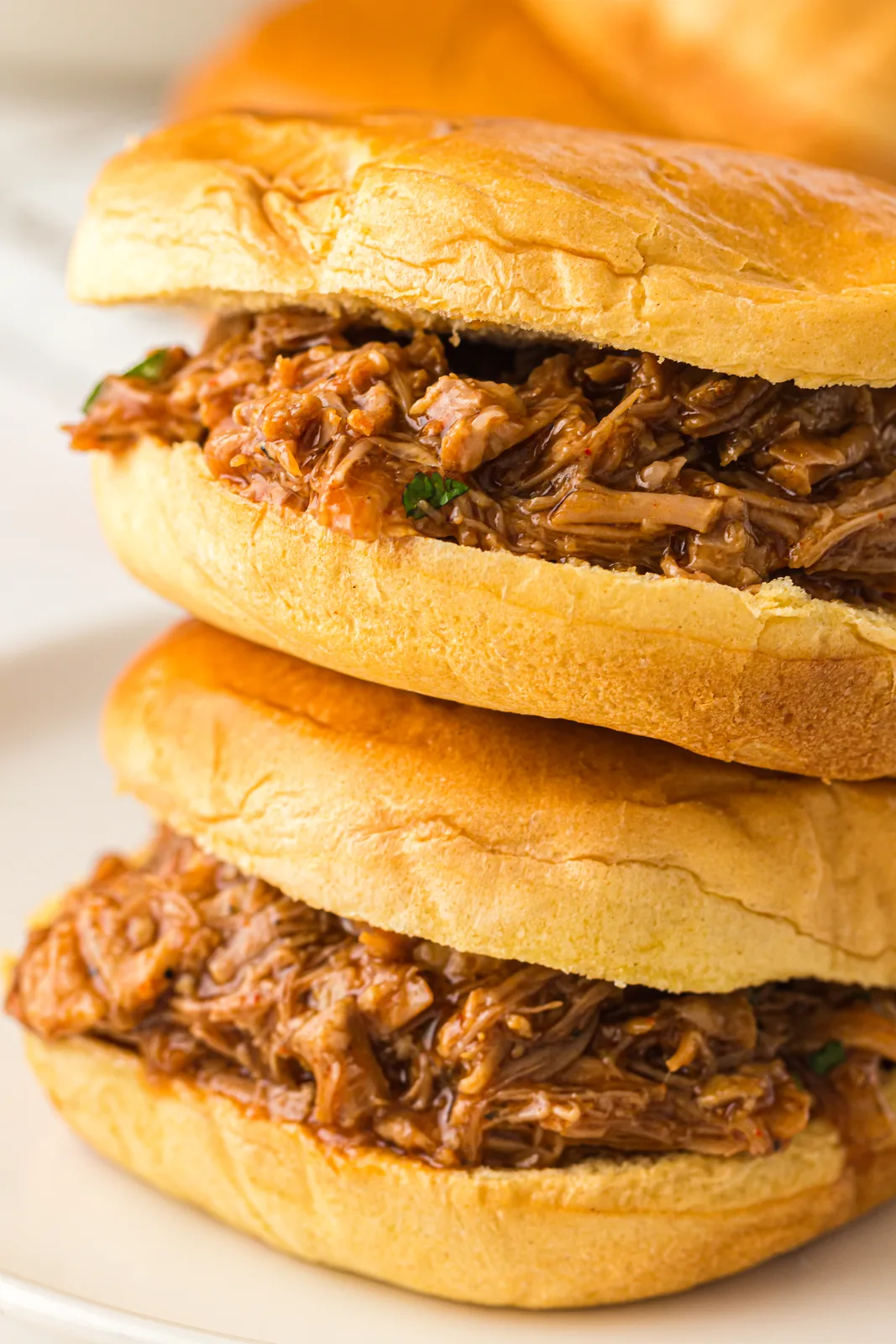 Two barbecue sandwiches stacked on soft buns